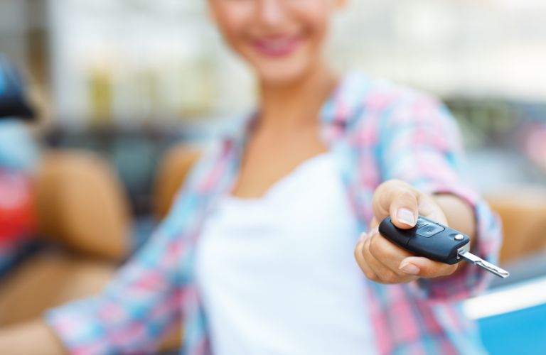 A smiling woman showing a key